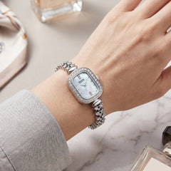 Mark Fairwhale silver crystal watch with mother-of-pearl dial on feminine wrist over marble surface