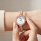 Mark Fairwhale women's rose gold quartz watch with crystal bezel, mother of pearl dial, decorative bracelet, and luxury wrist close up