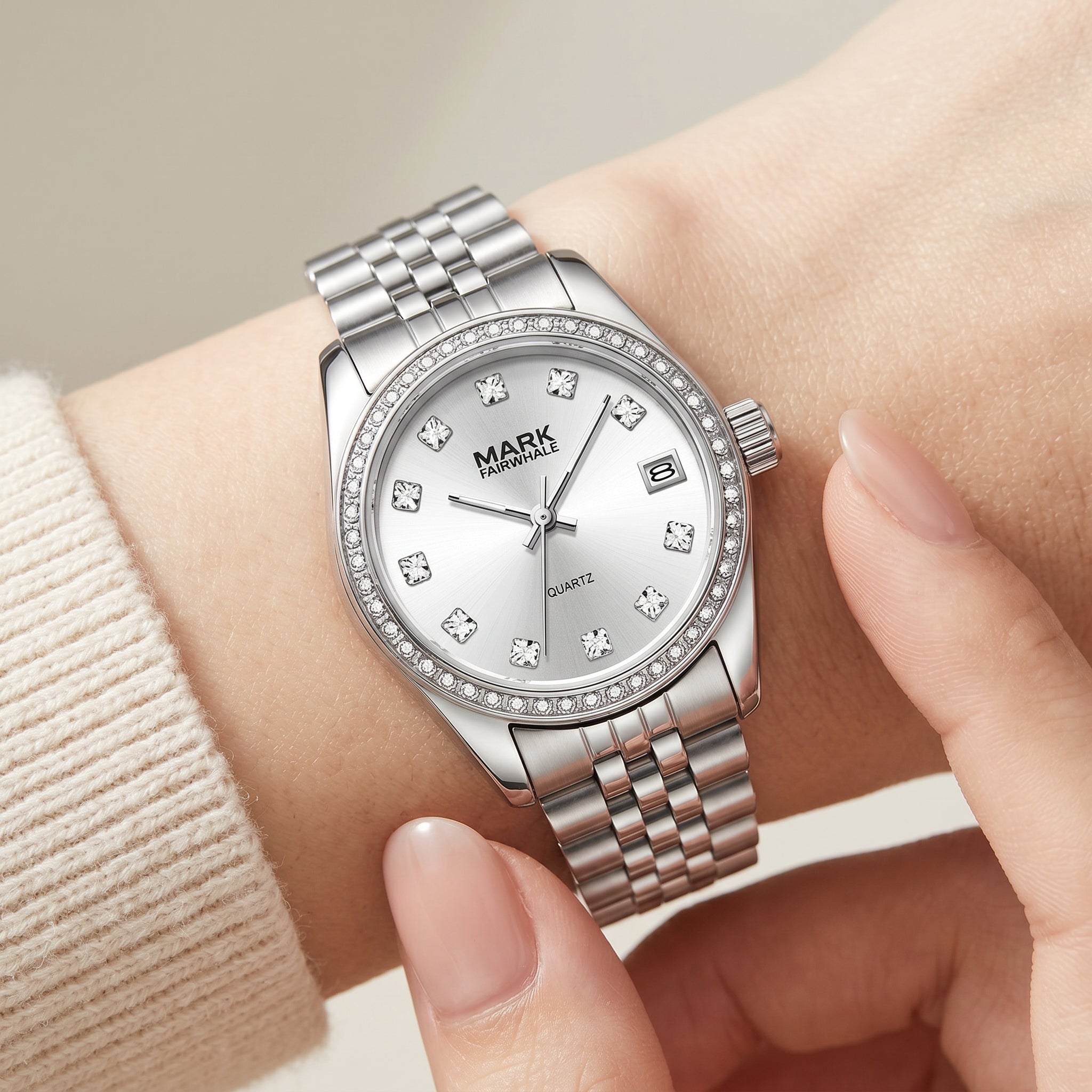 Mark Fairwhale women's silver dial quartz watch with polished metal bracelet, crystal bezel, date display, crystal hour markers, and elegant wrist close up