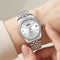 Mark Fairwhale women's silver dial quartz watch with polished metal bracelet, crystal bezel, date display, crystal hour markers, and elegant wrist close up