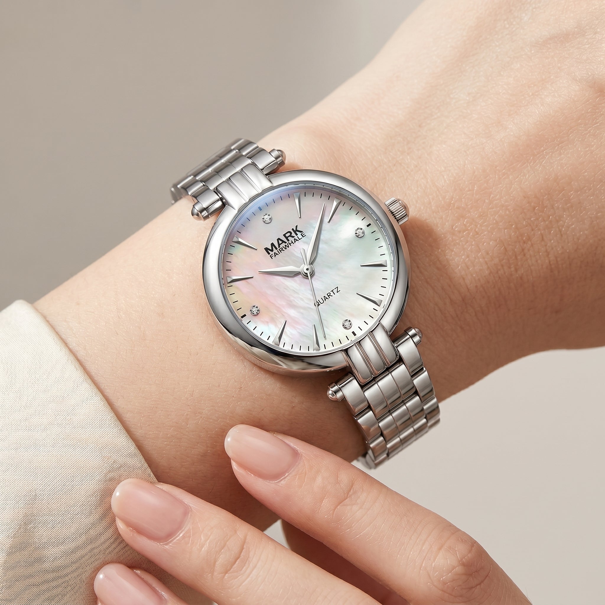 Mark Fairwhale women's silver quartz watch on wrist with mother of pearl dial, crystal hour markers, and polished metal bracelet
