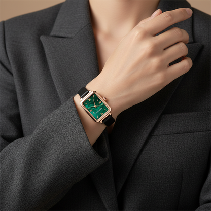 Person wearing a rose gold watch with a green face on a dark suit background