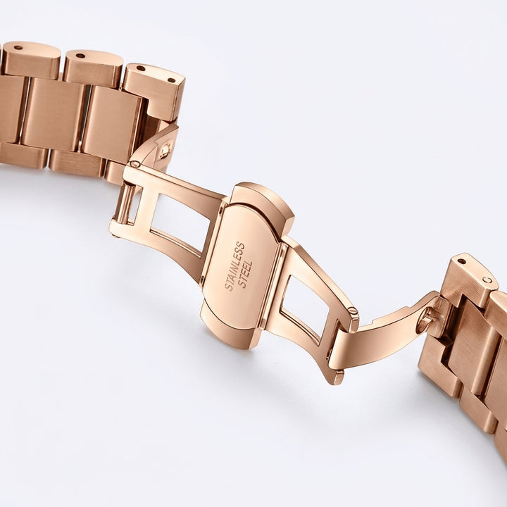 Rose gold watch bracelet on a light gray background