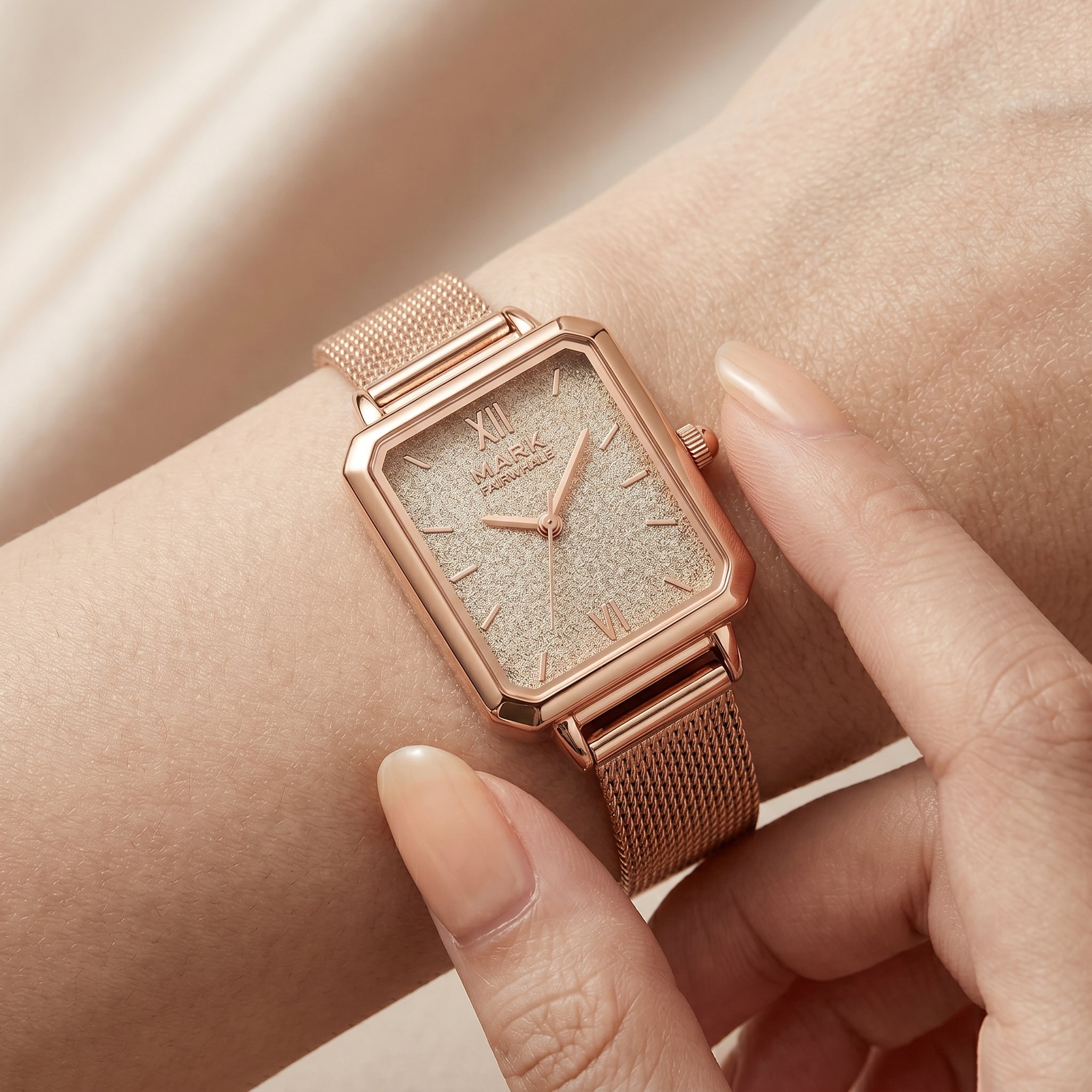 Rose gold watch on a wrist with a soft background