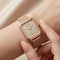 Rose gold watch on a wrist with a soft background