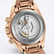 Rose gold watch with mechanical components on a light gray background
