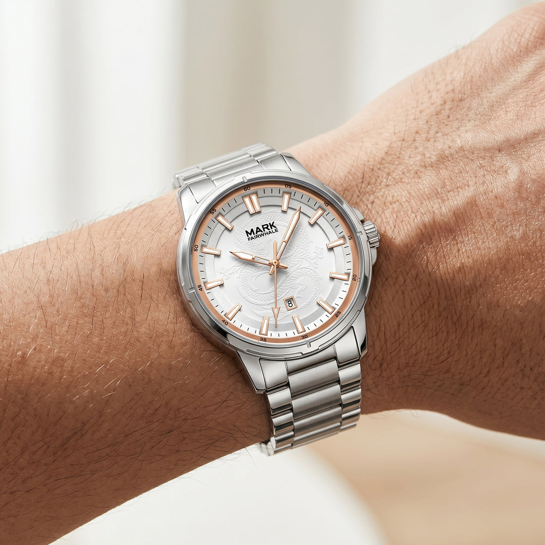 Silver watch with a white face on a wrist against a neutral background