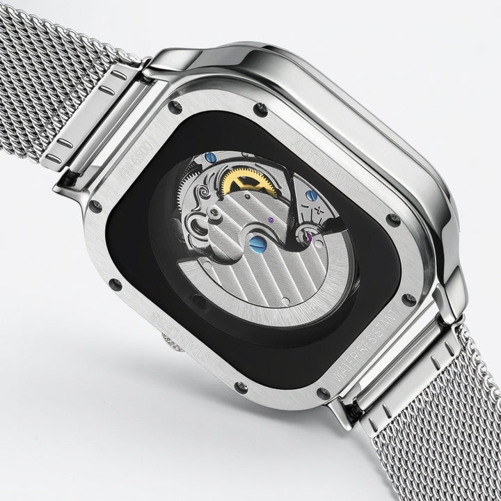 Silver watch with mesh band and open face design on a light gray background