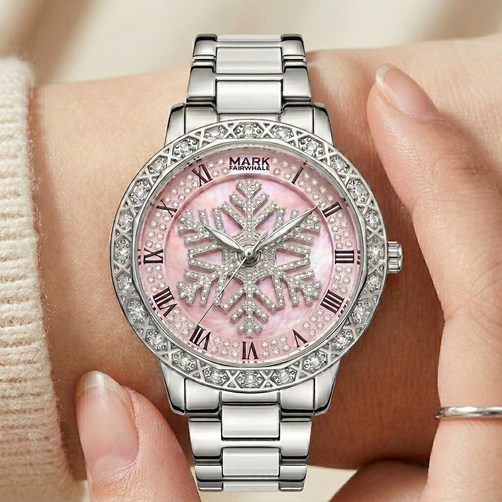 Silver watch with pink face and snowflake design on a wrist.
