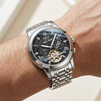Silver wristwatch with detailed face on a wrist against a neutral background