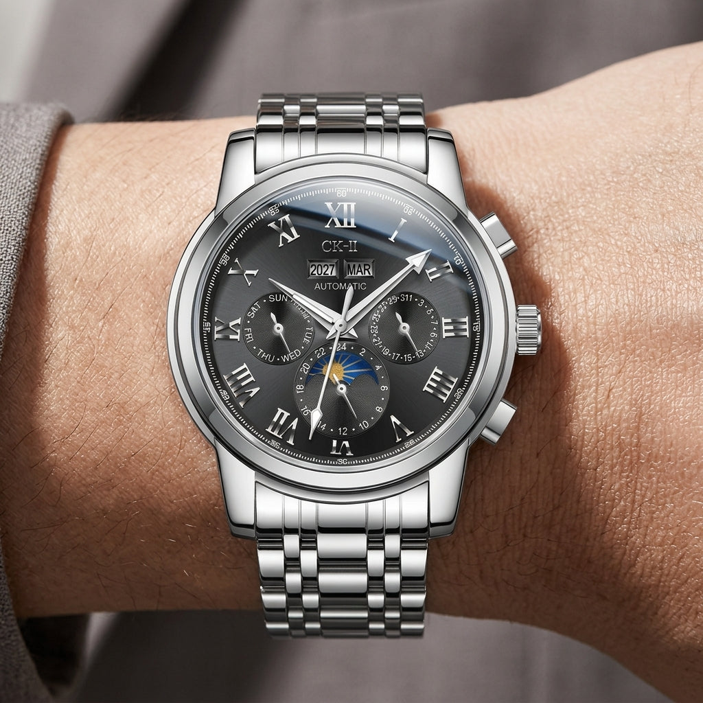 Silver wristwatch with a detailed black face on a wrist, against a neutral background