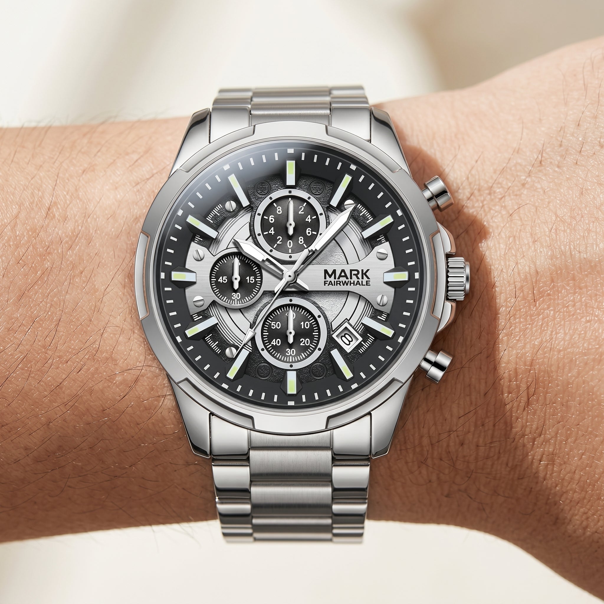 Silver wristwatch with a detailed face on a wrist against a neutral background