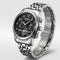 Silver wristwatch with black dial on a light gray background