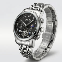 Silver wristwatch with black dial on a light gray background