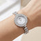 Silver wristwatch with gemstone accents on a wrist against a neutral background