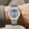 Silver wristwatch with intricate design on a wrist against a neutral background