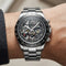 Silver wristwatch with visible brand name on a person's wrist against a neutral background