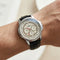 Watch with a detailed face on a wrist against a neutral background