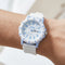 White and blue watch on a wrist with a blurred background