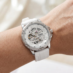 White wristwatch with visible brand name on a wrist against a neutral background