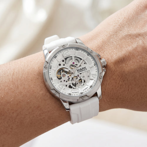 White wristwatch with visible brand name on a wrist against a neutral background