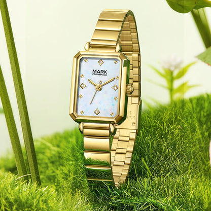 Mark Fairwhale FW-3070 ALERIA Women’s Square Quartz Watch with white mother-of-pearl dial and gold bracelet, standing on natural background.