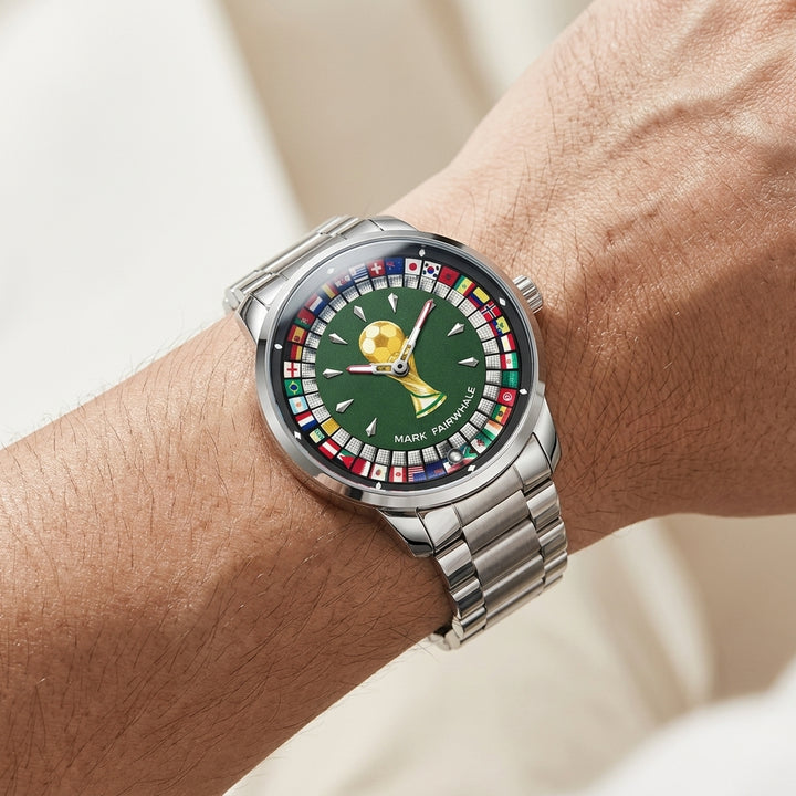 Silver watch with a detailed green face on a wrist against a neutral background